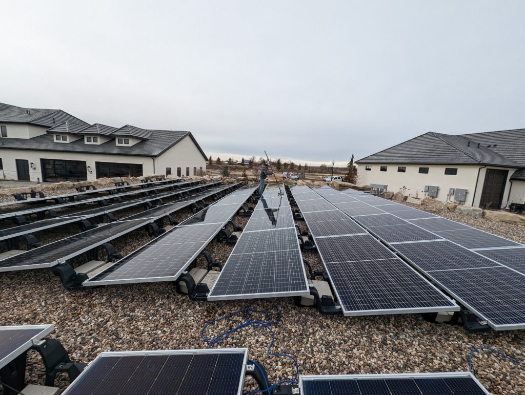 Clear Choice: Rows of solar panels in a residential area with houses in the background under a cloudy sky in the Boise Valley.