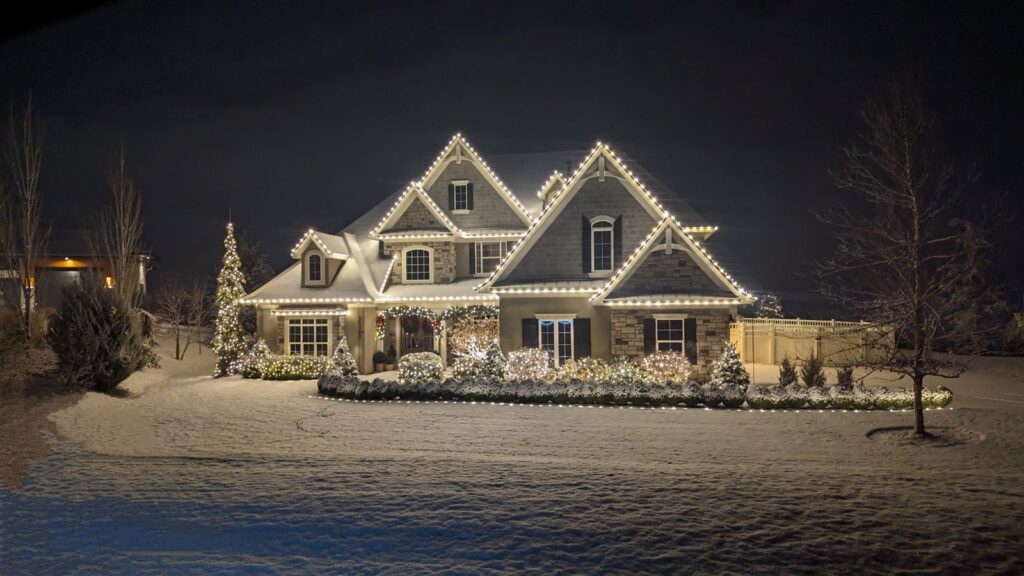 Clear Choice: A large two-story home adorned with white Christmas lights, surrounded by a snowy landscape at night, reflecting elegant interior design.