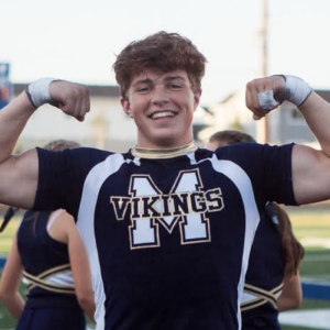 Clear Choice: A person in a "Vikings" cheer uniform smiles while flexing their arms outdoors.